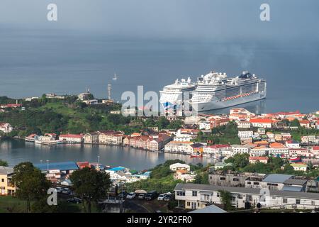 St. George's, Grenada - 4. Januar 2018: Kreuzfahrtschiffe legen am Hafen an und bieten einen Blick auf die farbenfrohe Stadt und das üppige Grün. Stockfoto