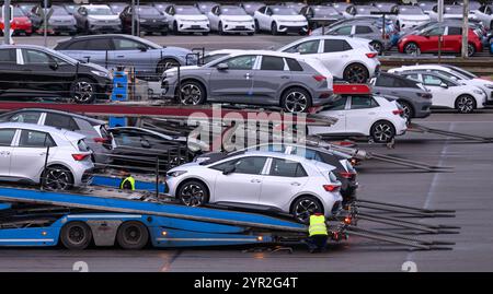 Zwickau, Deutschland. Dezember 2024. Neuwagen werden auf einem Parkplatz auf dem Volkswagen-Werksgelände zur Auslieferung geladen. Im Werk Zwickau werden ausschließlich vollelektrische Fahrzeuge der Marken des VW-Konzerns hergestellt. Quelle: Hendrik Schmidt/dpa/Alamy Live News Stockfoto