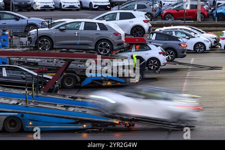 Zwickau, Deutschland. Dezember 2024. Neuwagen werden auf einem Parkplatz auf dem Volkswagen-Werksgelände zur Auslieferung geladen. Im Werk Zwickau werden ausschließlich vollelektrische Fahrzeuge der Marken des VW-Konzerns hergestellt. Quelle: Hendrik Schmidt/dpa/Alamy Live News Stockfoto