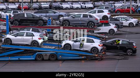 Zwickau, Deutschland. Dezember 2024. Neuwagen werden auf einem Parkplatz auf dem Volkswagen-Werksgelände zur Auslieferung geladen. Im Werk Zwickau werden ausschließlich vollelektrische Fahrzeuge der Marken des VW-Konzerns hergestellt. Quelle: Hendrik Schmidt/dpa/Alamy Live News Stockfoto