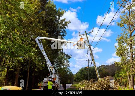 Bei Reparaturen an der Stromleitung wird die Ausrüstung mithilfe eines hydraulischen Hubwerks an der Versorgungsmaste montiert. Stockfoto