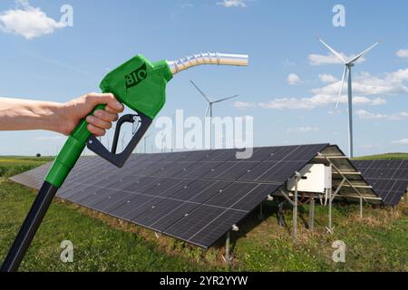 Hand mit Biobrennstoff-Betankungsdüse auf einem Hintergrund von Solarpaneelen. Stockfoto