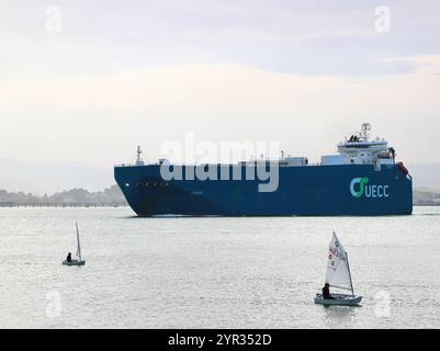 Ro-Ro-Fahrzeuge transportieren Frachtschiff Autosun, das den Hafen verlässt, vorbei an Segelschuljollen in einer ruhigen Morgenbucht von Santander Kantabrien Spanien Europa Stockfoto