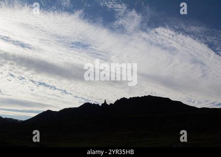 Die Silhouette eines markanten Berges vor einem atemberaubenden Himmel voller Wolken schafft eine dramatische und friedliche isländische Szene Stockfoto