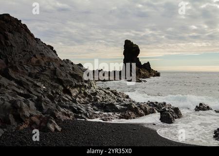 Die zerklüftete Vulkanküste Islands trifft in einer dramatischen Landschaft auf das Meer Stockfoto