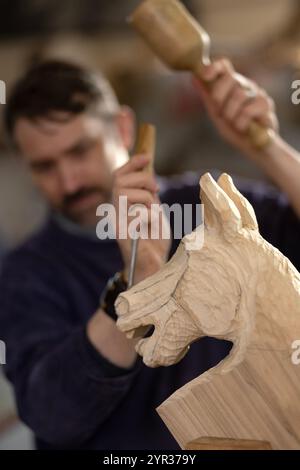 29/11/24 Pete Rix schneidet einen Pferdekopf aus Tulpenholz. Der Holzblock wird in einer Klammer, die als „Schnitzereien Häckselstock“ bezeichnet wird, fest gehalten. Seltenes Schaukeln H Stockfoto