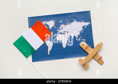 Weltkarte, Flagge von Irland und hölzernes Spielzeugflugzeug auf weißem Hintergrund Stockfoto