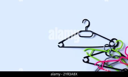 Kleiderbügel aus Kunststoff. Verkäufe, Rabatte, Einkäufe. Gestapelte leere Kleiderbügel aus Kunststoff auf hellgrauem Hintergrund. Minimalismus Stockfoto