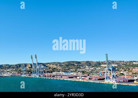 Marseille. Frankreich - 2. Dezember 2024: Hafen von Marseille an einem sonnigen Tag mit Fähre und Kreuzfahrtschiff, mit Stadt und Bergen Stockfoto