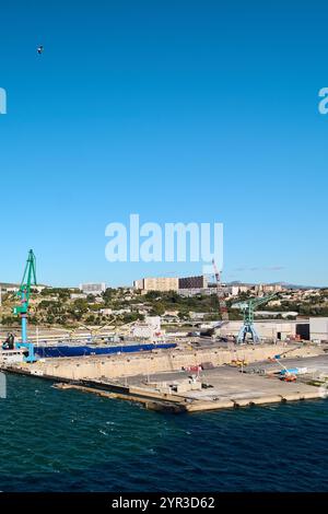 Marseille. Frankreich - 2. Dezember 2024: Malerischer Blick auf den Hafen von Marseille mit einer Fähre und einem Kreuzfahrtschiff, mit der Stadt und den Bergen Stockfoto