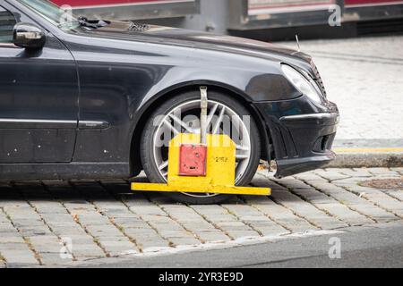 Radklemme von der Mestska Polizei an einem Auto auf der Straße. Ein beschädigtes Fahrzeug wird in der Stadt Prag geparkt oder aufgegeben. Bewegung ist gesperrt. Stockfoto