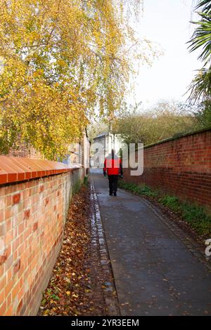 Mann in roter Jacke, der den Riverside Walk in Norwich hinaufläuft Stockfoto