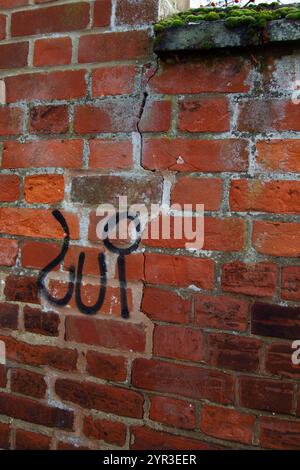 Graffiti auf eine rissige Mauer Stockfoto