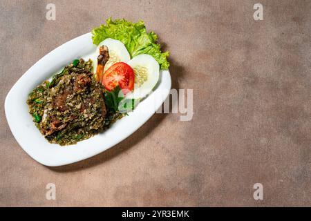 Bebek Goreng Cabe ijo oder gebratene Ente mit grüner Chili-Sauce. Traditionelle Küche aus West Sumatra, Indonesien. Stockfoto