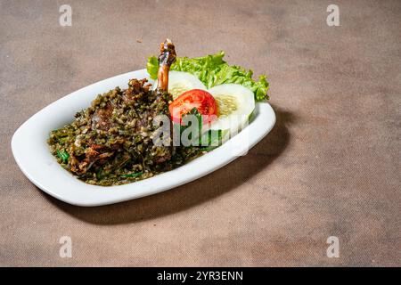 Bebek Goreng Cabe ijo oder gebratene Ente mit grüner Chili-Sauce. Traditionelle Küche aus West Sumatra, Indonesien. Stockfoto