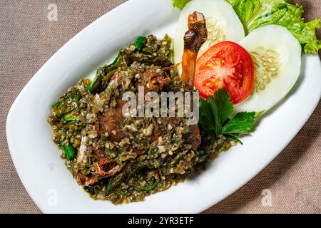 Bebek Goreng Cabe ijo oder gebratene Ente mit grüner Chili-Sauce. Traditionelle Küche aus West Sumatra, Indonesien. Stockfoto