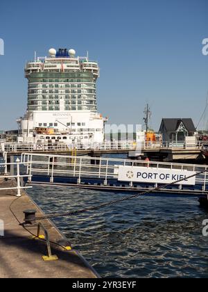 Stern des großen P und O Kreuzfahrtschiffes Britannia, der im Hafen Kiel verankert ist - eine Gangplanke mit dem Text Hafen Kiel im Vordergrund. Stockfoto