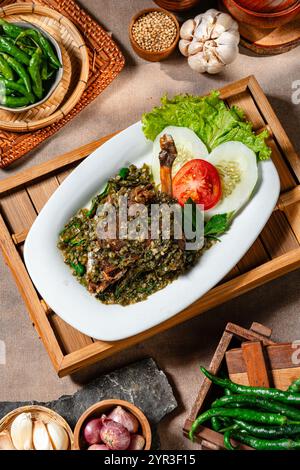 Bebek Goreng Cabe ijo oder gebratene Ente mit grüner Chili-Sauce. Traditionelle Küche aus West Sumatra, Indonesien. Stockfoto