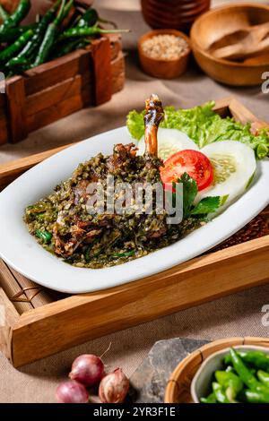 Bebek Goreng Cabe ijo oder gebratene Ente mit grüner Chili-Sauce. Traditionelle Küche aus West Sumatra, Indonesien. Stockfoto