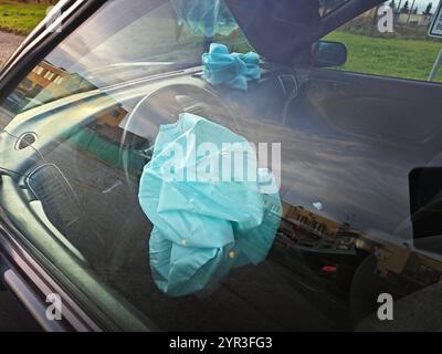 Innenraum eines Fahrzeugs, das an einem Frontalaufprall mit einem ausgelösten Lenksäulenairbag beteiligt ist. Stockfoto