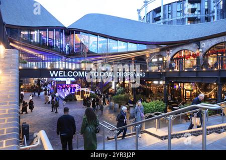 Coal Drops Yard zur Weihnachtszeit, mit Geschäften und Restaurants und den Gasholder Apartments dahinter, am Kings Cross im Norden Londons, Großbritannien Stockfoto