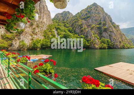 Touristen genießen eine friedliche Bootsfahrt auf dem ruhigen Matka See, umgeben von atemberaubenden Klippen und üppigem Grün des Matka Canyon in Mazedonien Stockfoto