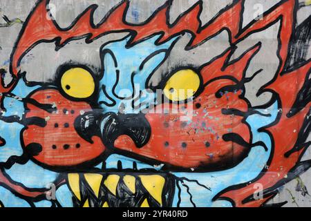 Wunderschöne, lebendige Zeichnungen und Tierbilder auf einer bräunlich-grauen Betonwand. Graffiti, ein großer Kopf, die Mündung eines Tigers mit Blau, Grau. Stockfoto