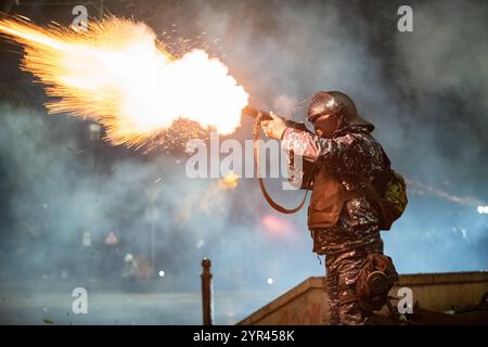 Tiflis, Georgien. Dezember 2024. Ein Polizist der Spezialkräfte feuert Tränengas auf pro-europäische Demonstranten in der fünften Nacht der Proteste ab. Quelle: Jay Kogler/Alamy Live News Stockfoto