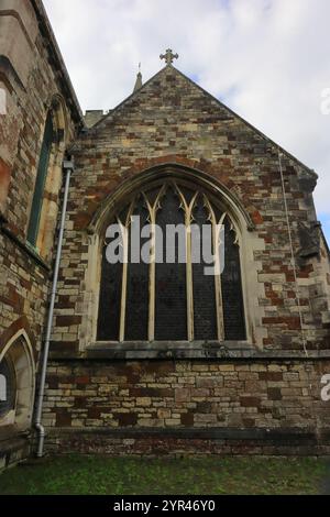 Wimborne Minster, Dorset, England. 4. Oktober 2024. Wimborne Minster, eine sächsische Kirche mit normannischer und gotischer Architektur: Farbiger Blick auf ein mehrtäfeliges Buntglasfenster, außen. Stockfoto