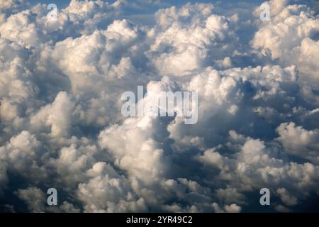 Aus der Vogelperspektive von oben in großer Höhe fliegende dichte, geschwollene Kumuluswolken. Fantastisch aus der Sicht des Flugzeugs Stockfoto