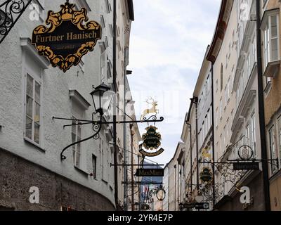 Salzburg, Österreich - 1. Oktober 2024: Historische Getreidegasse in Salzburg, Österreich, mit ikonischen Schildern aus Schmiedeeisen, Classic Storefronts Stockfoto