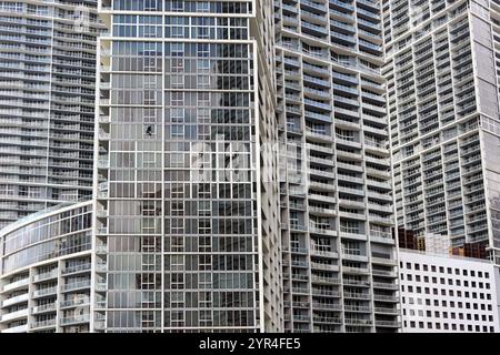 Miami, Florida, USA - 1. Dezember 2023: Außenansicht der Büro- und Mehrfamilienhäuser in der Innenstadt von Miami. Eine Person putzt die Fenster Stockfoto