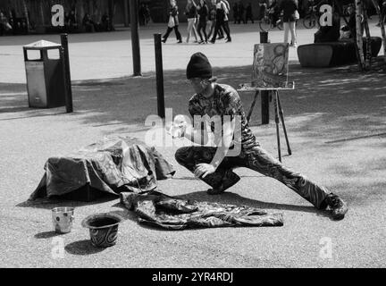 LONDON, ENGLAND, Großbritannien - 3. MAI 2014: Ein unbekannter junger Jongleur mit vier Kristallkugeln zeigt seine Kunst der Öffentlichkeit nahe der Tate Gallery. Die meisten Londoner Stadtteile Stockfoto