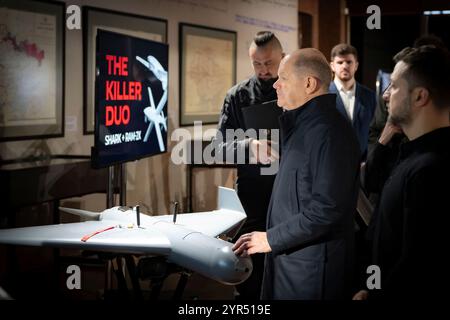 Kiew, Ukraine. Dezember 2024. Der ukrainische Präsident Wolodymyr Zelenskyj rechts und der deutsche Bundeskanzler Olaf Schotz, Center, betrachten UAV- und FPV-Drohnen, die in der Ukraine mit deutscher Technologie hergestellt wurden, 2. Dezember 2024 in Kiew, Ukraine. Kredit: Ukrainischer Ratsvorsitz/Pressestelle Des Ukrainischen Präsidenten/Alamy Live News Stockfoto