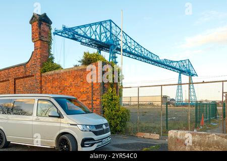 Stillgelegte hohe blaue Transporterbrücke mit klarem Himmel in der Industrielandschaft middlesbrough Teesside UK mit volkswagen Transporter T6 im Vordergrund Stockfoto