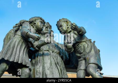 Statue, die Waagen der Gerechtigkeit mit einer Frau zeigt, die zwei streitende Kinder hält, befindet sich vor einem Kronhof von middlesbrough unter einem klaren blauen Himmel Stockfoto