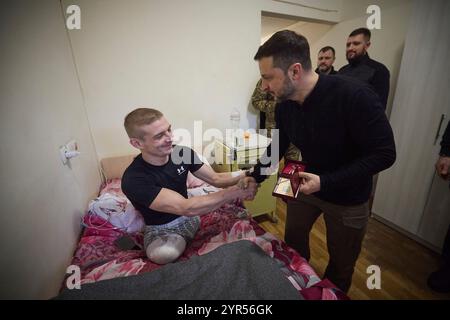 Kiew, Ukraine. Dezember 2024. Der ukrainische Präsident Wolodymyr Zelenskyj, rechts, vergibt am 2. Dezember 2024 in Kiew, Ukraine, eine Militärmedaille an verwundete Krieger, die sich in einem Militärkrankenhaus erholen. Kredit: Ukrainischer Ratsvorsitz/Pressestelle Des Ukrainischen Präsidenten/Alamy Live News Stockfoto