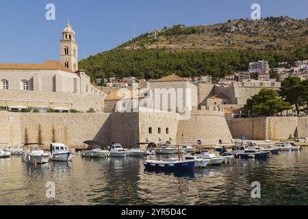 Alte ummauerte Stadt Dubrovnik mit dem Glockenturm des Dominikanerklosters und dem Zrinski Sightseeing-Boot, das im Hafen verankert ist, plus dem Mount SRD im Hintergrund Stockfoto