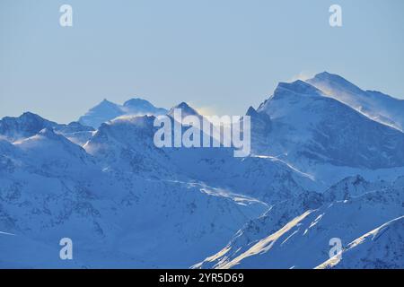 Schneebedeckte Berggipfel mit fliegendem Schnee, vor einem klaren blauen Himmel in einer winterlichen Landschaft, Leukerbad, Leuk, Wallis, Schweiz, Europa Stockfoto