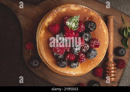 Frühstück, Pfannkuchen mit Beeren und Honig, Blick von oben, hausgemacht, keine Leute, auf einem hölzernen Hintergrund Stockfoto