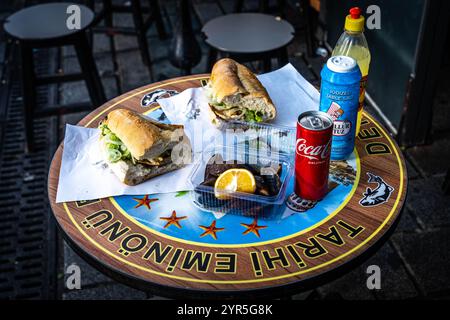 Gebratenes Fisch-Sandwich mit Muscheln auf dem Tisch. Türkischer Name Balik Ekmek Stockfoto