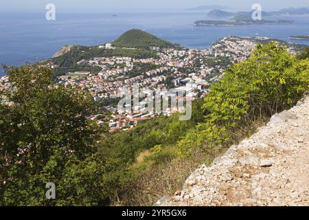 Blick aus einem hohen Winkel auf die Häuser und Villen mit braunen und weißen Zierelementen und die Dächer mit traditionellen Terrakottatziegeln, die vom Mount SRD im Spätsommer stammen, Dubrovnik, Stockfoto