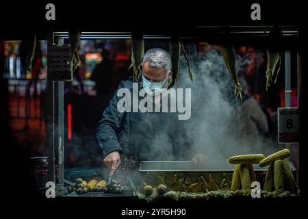 ISTANBUL, 9. JANUAR 2022: Ein Maisverkäufer am Abend im Zentrum von Istanbul, Türkei. Istanbul ist die größte Stadt der Türkei Stockfoto