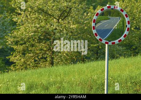 Verkehrsspiegel, der eine Straße, Bäume und Wiese im Hintergrund reflektiert, Odenwald, Hessen, Deutschland, Europa Stockfoto