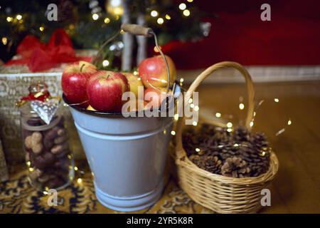 Weihnachtskomposition mit roten Äpfeln, Geschenken und Lebkuchen. Weihnachten im Retro-Stil. Vintage-Dekoration. Gemütliches Interieur. Stockfoto