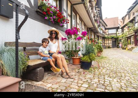 Mutter und Sohn sitzen im mittelalterlichen Dorf Gengenbach im Schwarzwald, Deutschland, Familienurlaubskonzept, Europa Stockfoto