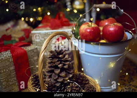 Weihnachtskomposition mit roten Äpfeln, Geschenken und Lebkuchen. Weihnachten im Retro-Stil. Vintage-Dekoration. Gemütliches Interieur. Stockfoto