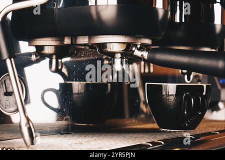 Kaffeezubereitung in einem Café mit professioneller Kaffeemaschine. Auf der Kaffeemaschine sind Wassertropfen zu sehen. Nahaufnahme des Coffee-Shops. Stockfoto