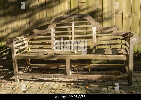 Holzbank vor Holzzaun Licht und Schatten Stockfoto