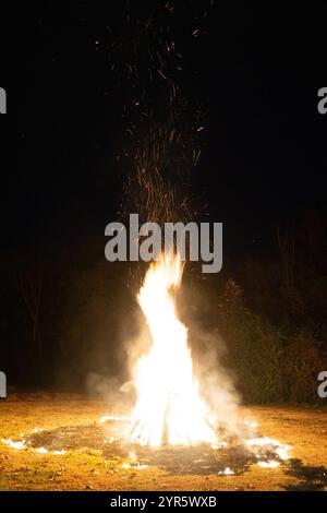 Helles Lagerfeuer unter einem Sternenhimmel mit Funkenflug Stockfoto